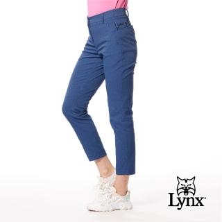 【Lynx Golf】女款日本進口布料抗皺彈性舒適丹寧風格織帶剪接設計草寫繡花造型窄管九分褲(深藍牛仔色)